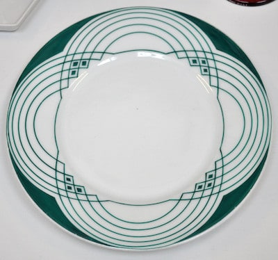 Weißer Teller mit grünem geometrischem Liniendekor aus dem lokalen Peter-Behrens-Bildbestand.