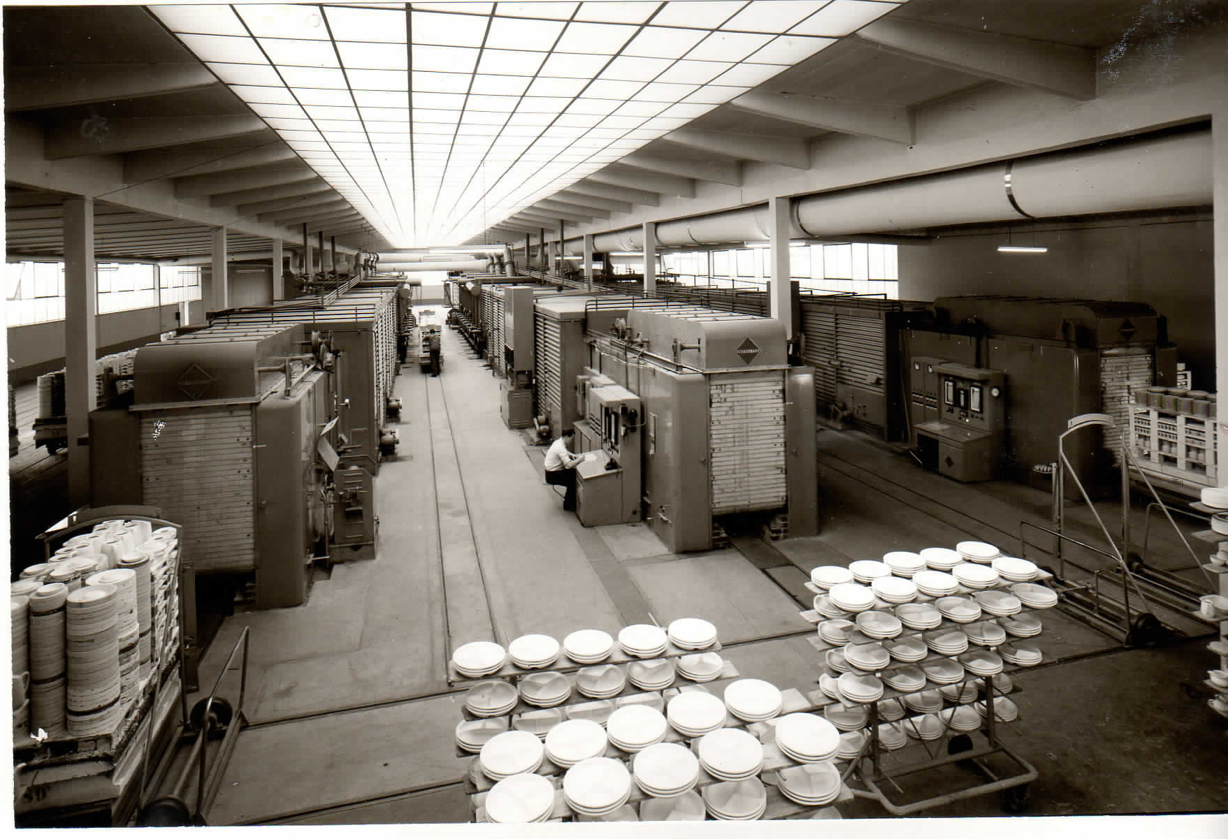 Halle mit nebeneinanderliegenden Tunnelöfen, Transportwagen, gestapelten Tellern und Beschäftigten, 1971 laut Albumlegende.