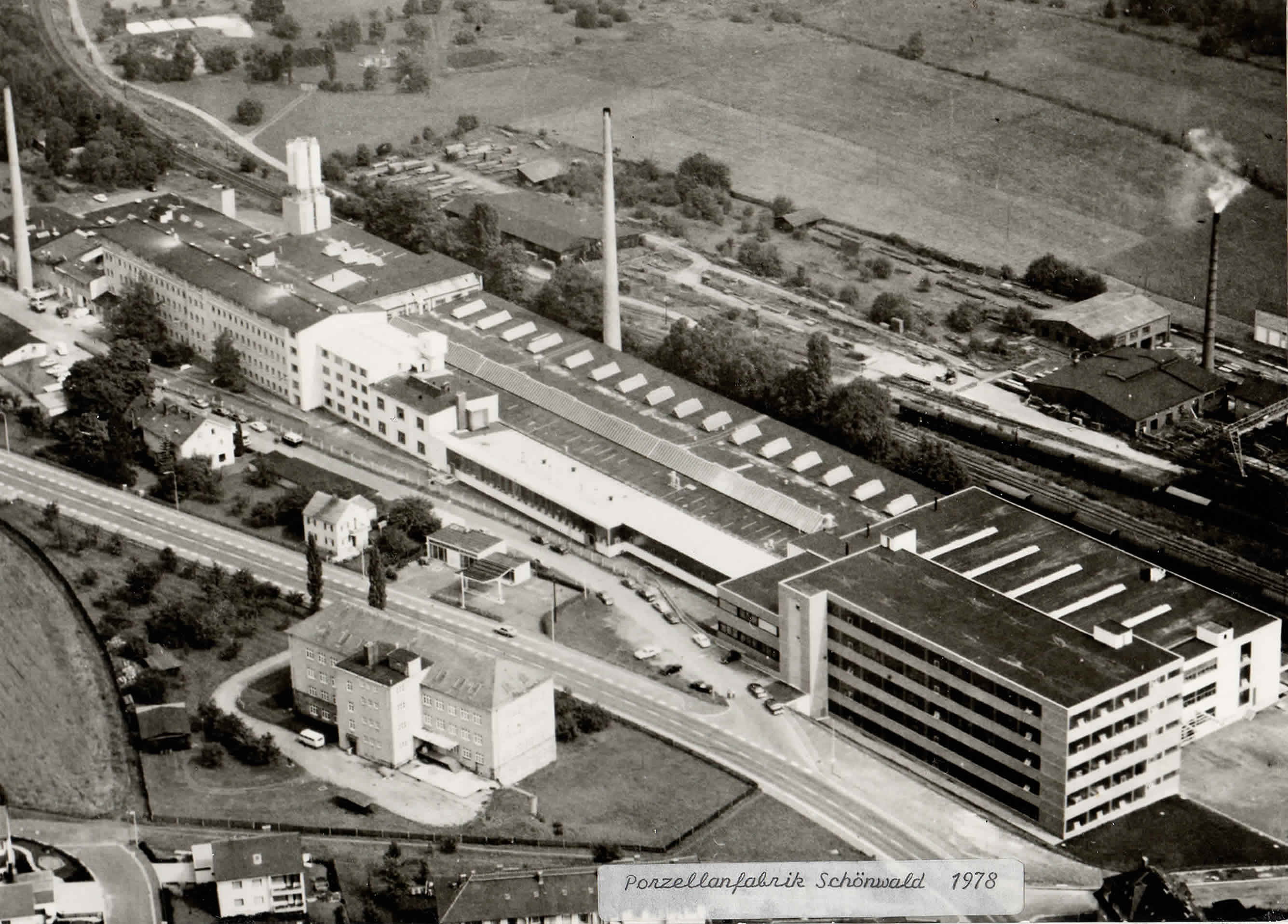 Schwarzweiß-Luftaufnahme des Schönwalder Werks mit Hallen und Bahnumfeld, 1978.