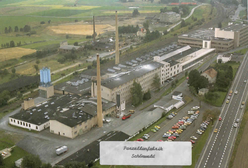 Farbige Luftaufnahme der Schönwalder Porzellanfabrik mit Parkplatz und angrenzenden Flächen.