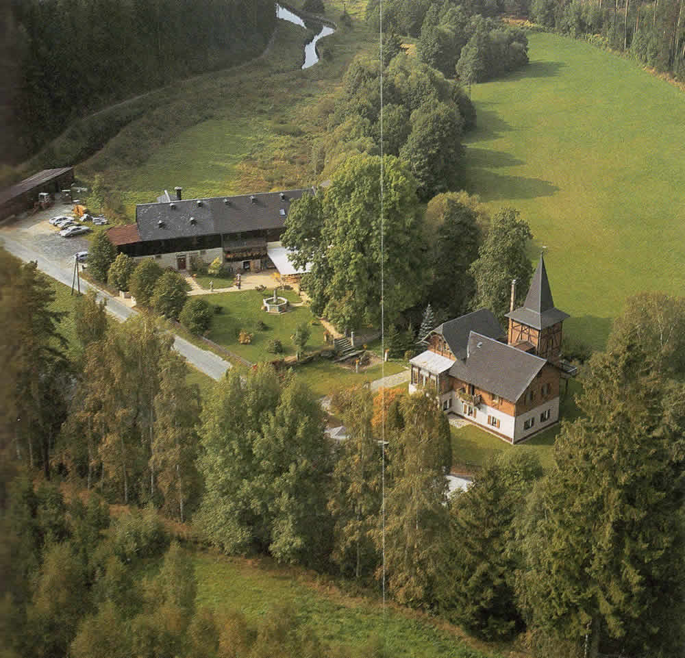 Luftaufnahme von Gut Blumenthal mit Villa, Nebengebäuden und Wasserlauf.