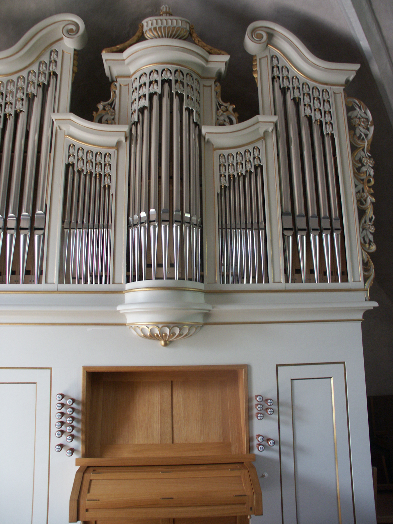 Orgel auf der Westempore. Der Prospekt ist in drei Teile gegliedert und weiß-gold gefasst. Bildserie 2005.