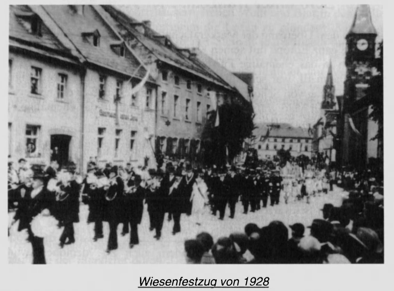 Historischer Festzug mit Musikern, Fahnen und Zuschauern, in der FGV-Chronik auf 1928 datiert.