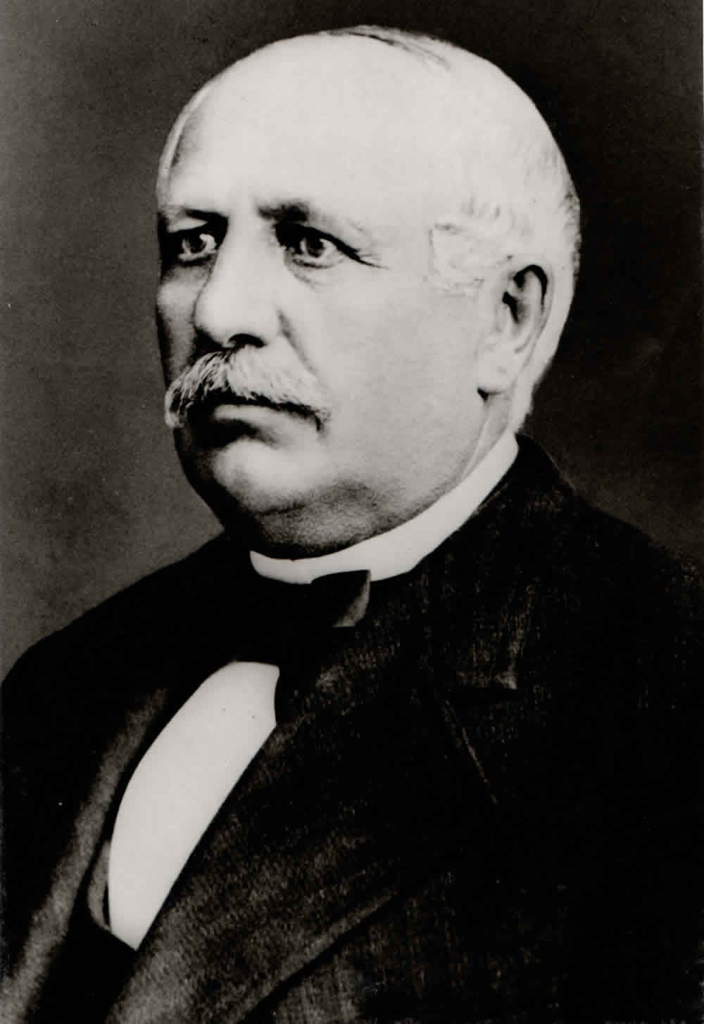 Schwarzweißporträt von Lorenz Hutschenreuther in dunklem Anzug.