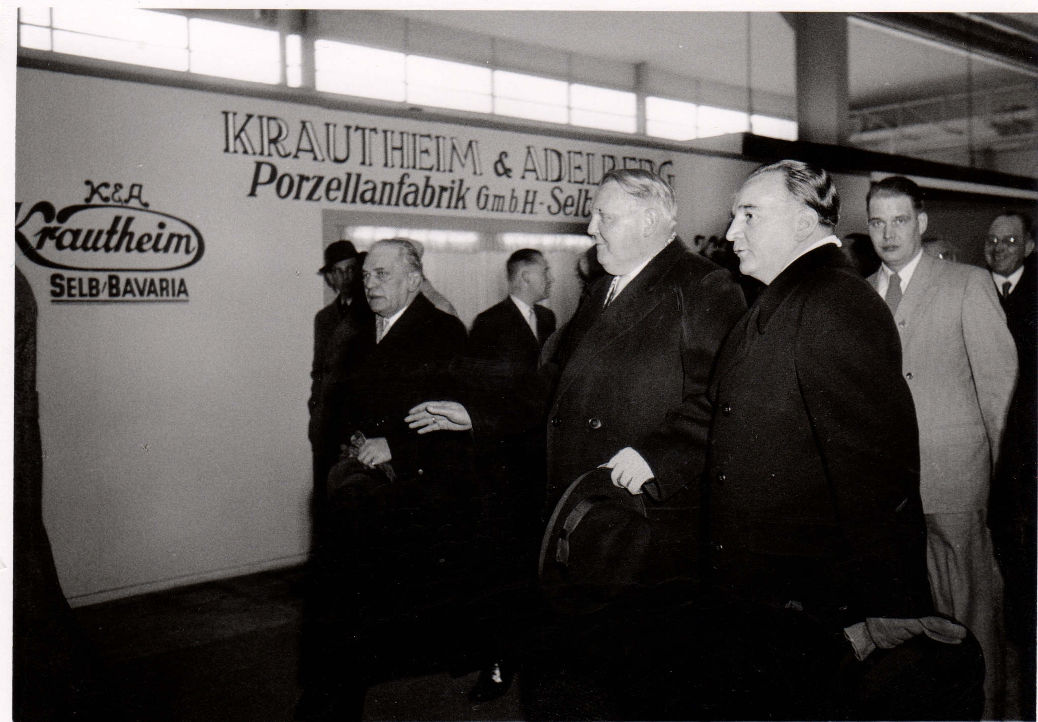 Mehrere Männer vor einem Ausstellungsstand mit der Aufschrift Krautheim und Adelberg Porzellanfabrik GmbH Selb.