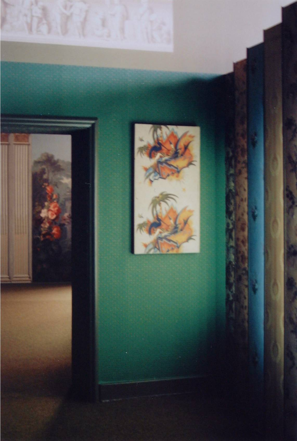Museale Präsentation zweier farbiger Tapetenbahnen mit figürlichen und pflanzlichen Motiven.