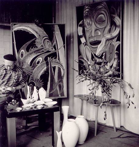 Historischer Blick in ein Atelier mit großen fantasievollen Bildern, Pflanzen und Porzellanvasen.