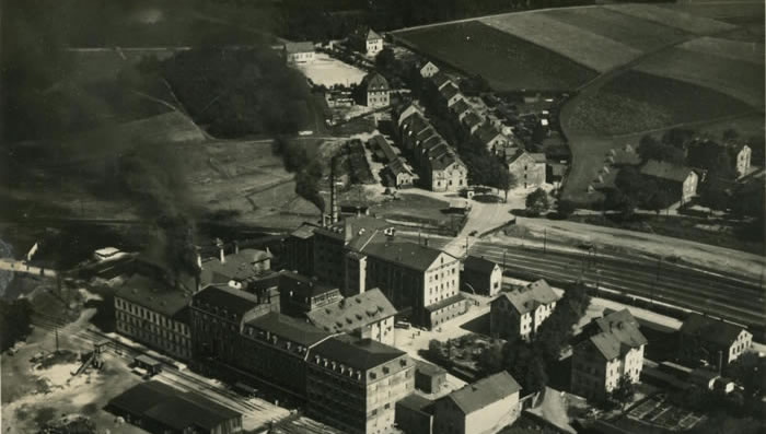 Historische Luftaufnahme von Fabrikgebäuden, Gleisen und Wohnhäusern in Selb-Plößberg.
