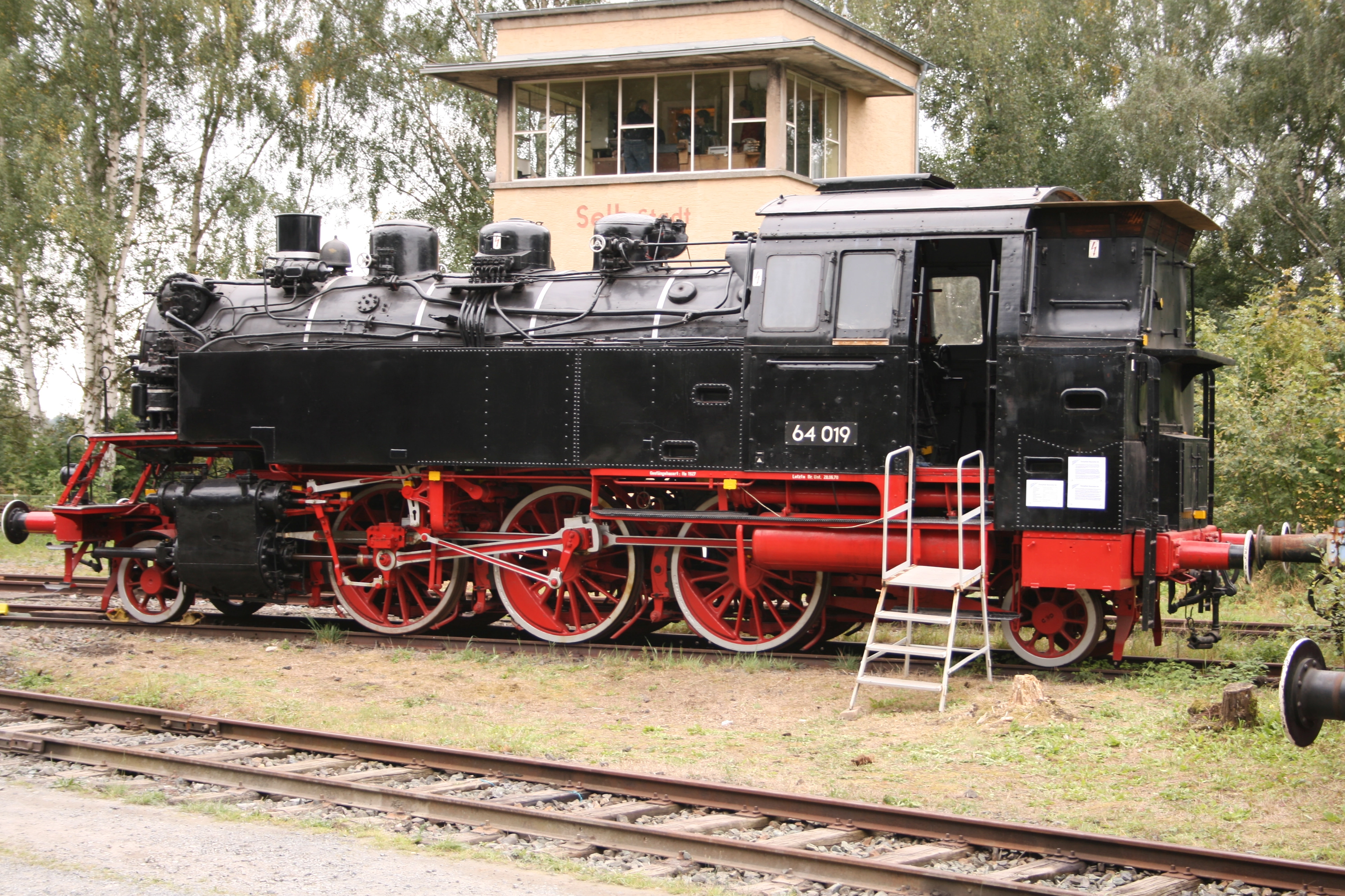 Schwarze Dampflokomotive 64 019 mit rotem Fahrwerk auf dem Museumsgleis.