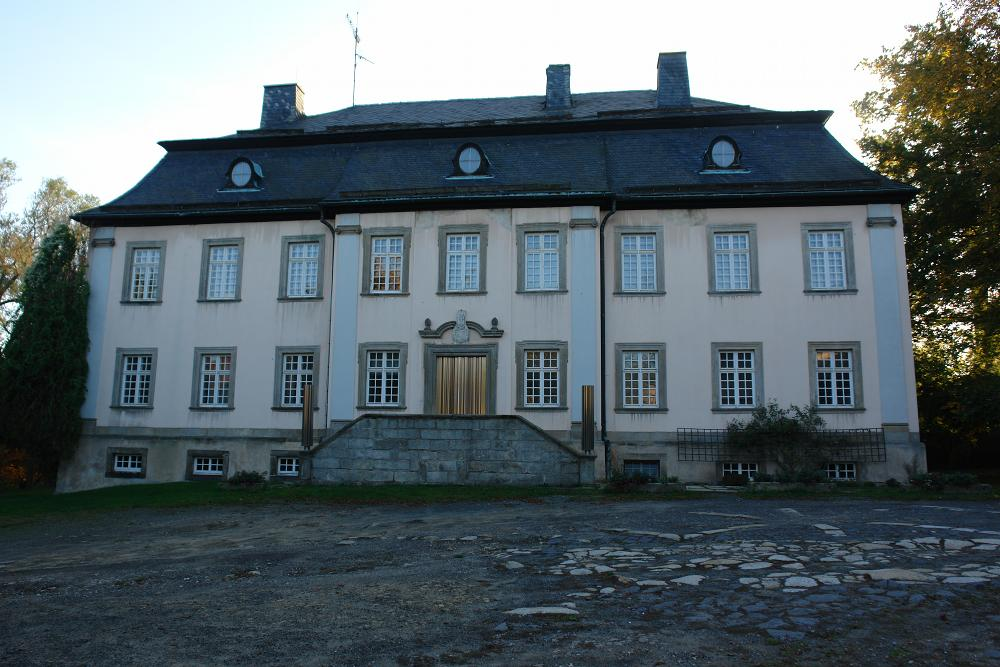 Frontansicht von Schloss Erkersreuth mit Eingangstreppe und gepflastertem Vorplatz.