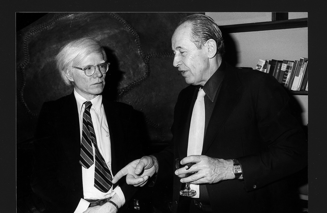 Andy Warhol und Philip Rosenthal im Gespräch, Rosenthal hält ein Glas in der Hand.