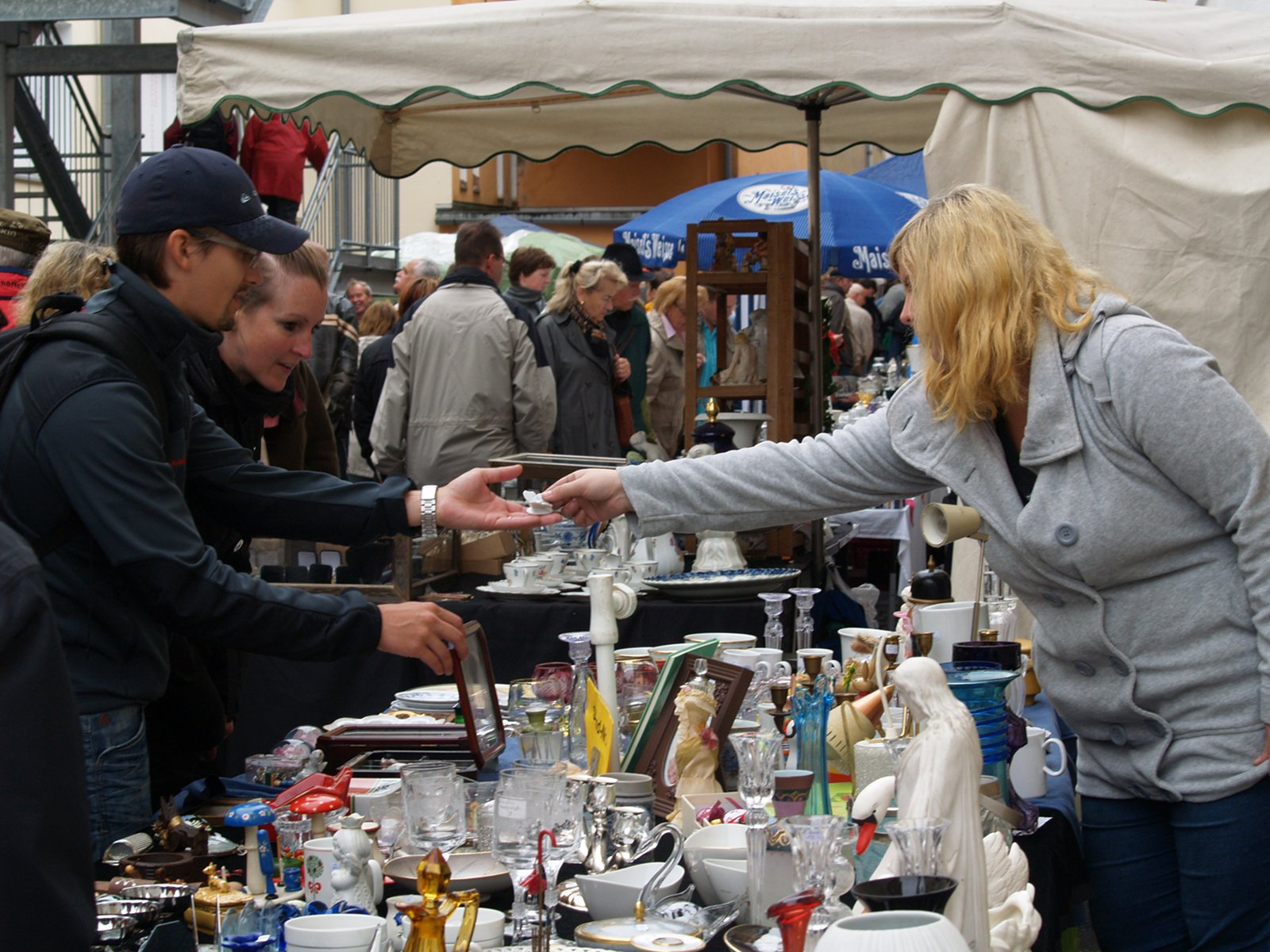 Menschen und Hände über einem Porzellanverkaufstisch am 7. August 2010.