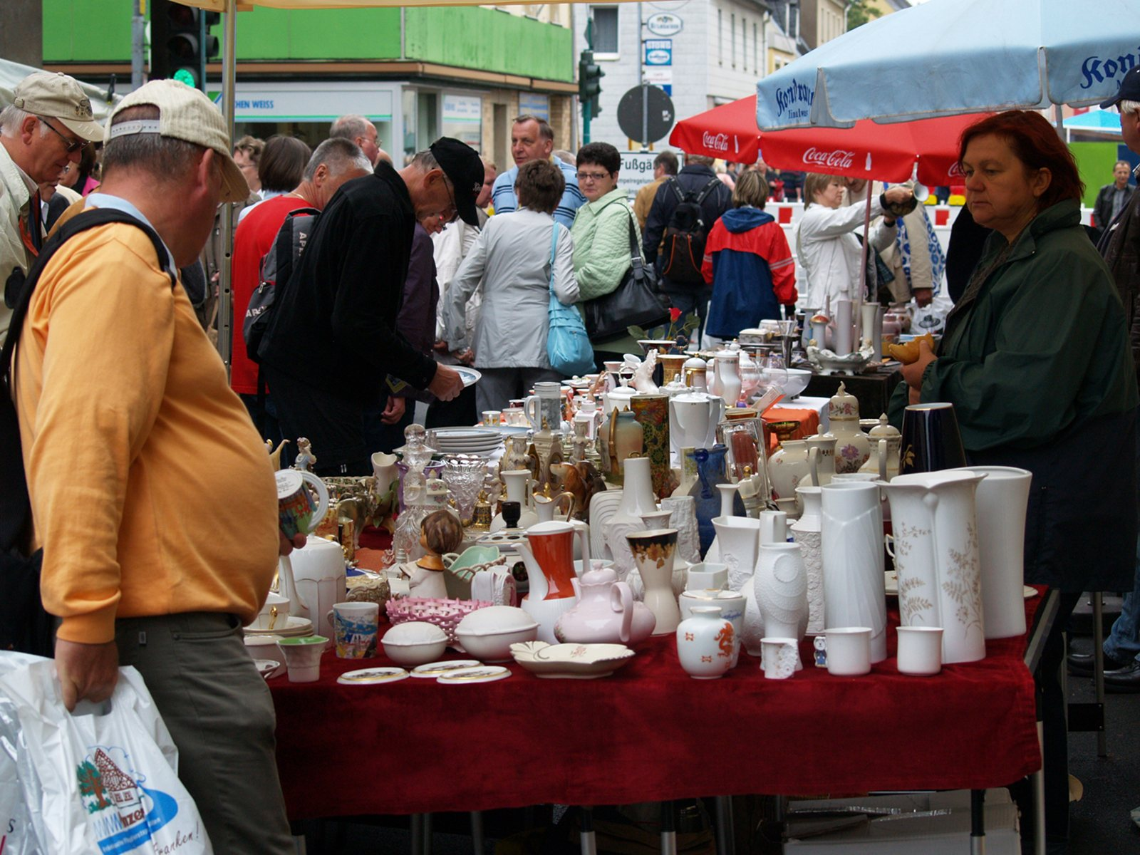 Lange Verkaufstische mit Porzellan und Besuchern am 7. August 2010.