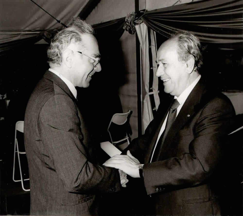 Schwarzweißfoto: Christian Höfer gratuliert Roland Dorschner beim Firmenjubiläum 1982.