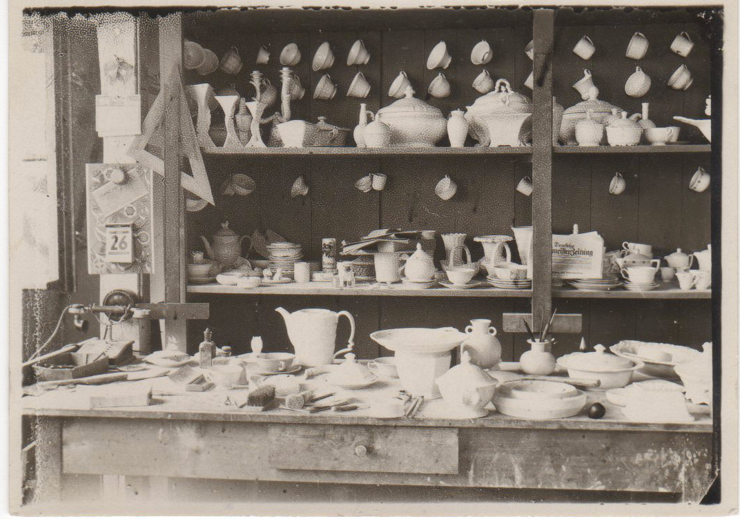 Sortiment im Ausstellungsraum. Kannen, Tassen, Terrinen, Vasen und Figuren auf Tisch und Regalen. Original erkersreuth009.jpg, Ordner bahnhof-selb-motive.