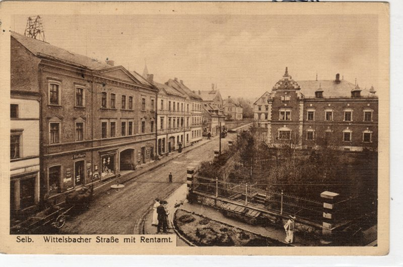Historische Postkarte der Wittelsbacher Straße mit Rentamt, Häuserzeile und einer Einfassung im Vordergrund.