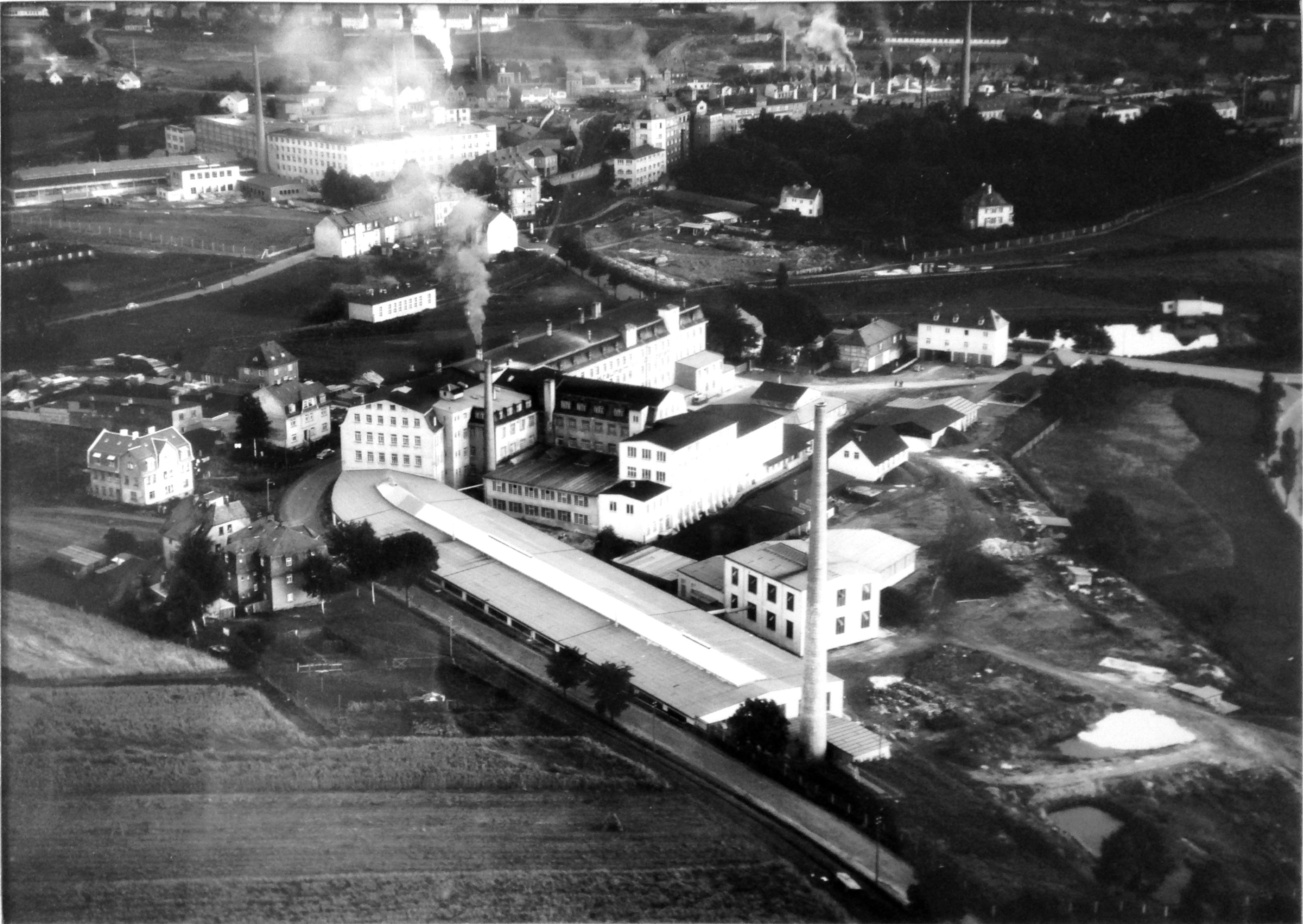Historische Luftaufnahme des im Thomas-Marktredwitz-Bestand überlieferten Fabrikgeländes mit Schornsteinen und angrenzender Bebauung.