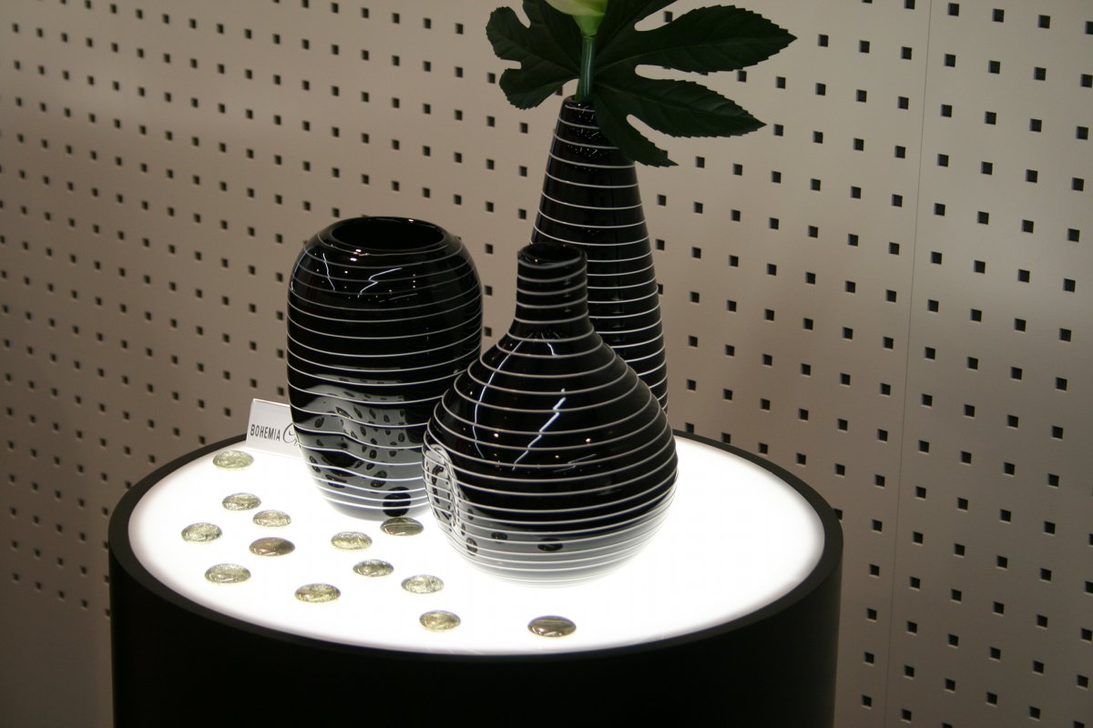 Dunkle Vasen mit hellen Linien auf einer runden weißen Ausstellungsfläche, 2009.