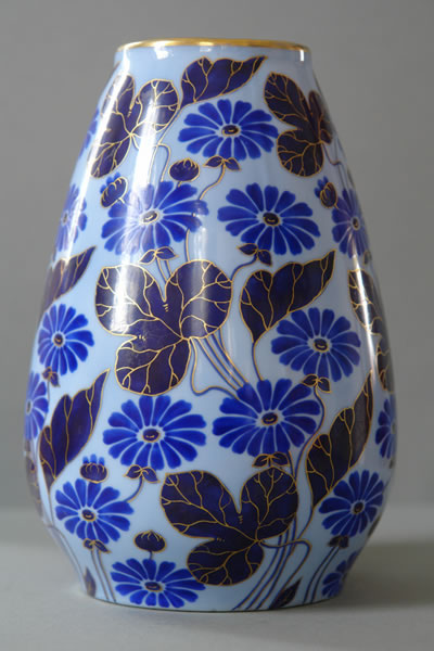 Vase mit dichtem blauem Blüten- und Blattdekor auf weißem Grund.